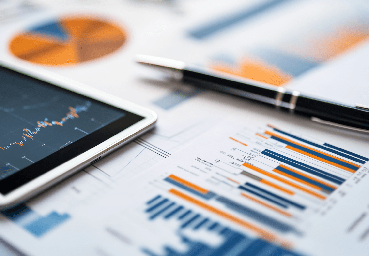 Tablet showing a growth chart next to printed reports on a desk